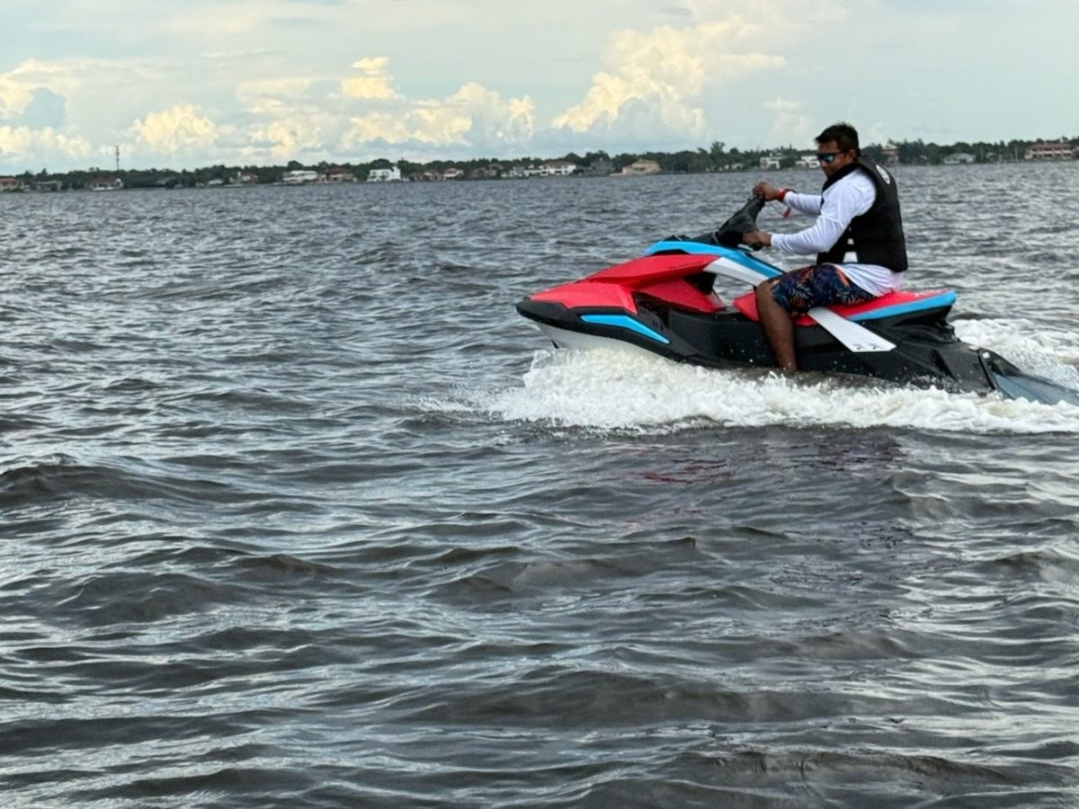 Man riding a jet ski on a wide, open body of water.